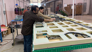 2 people working on large DUNE Charge Readout Plane.